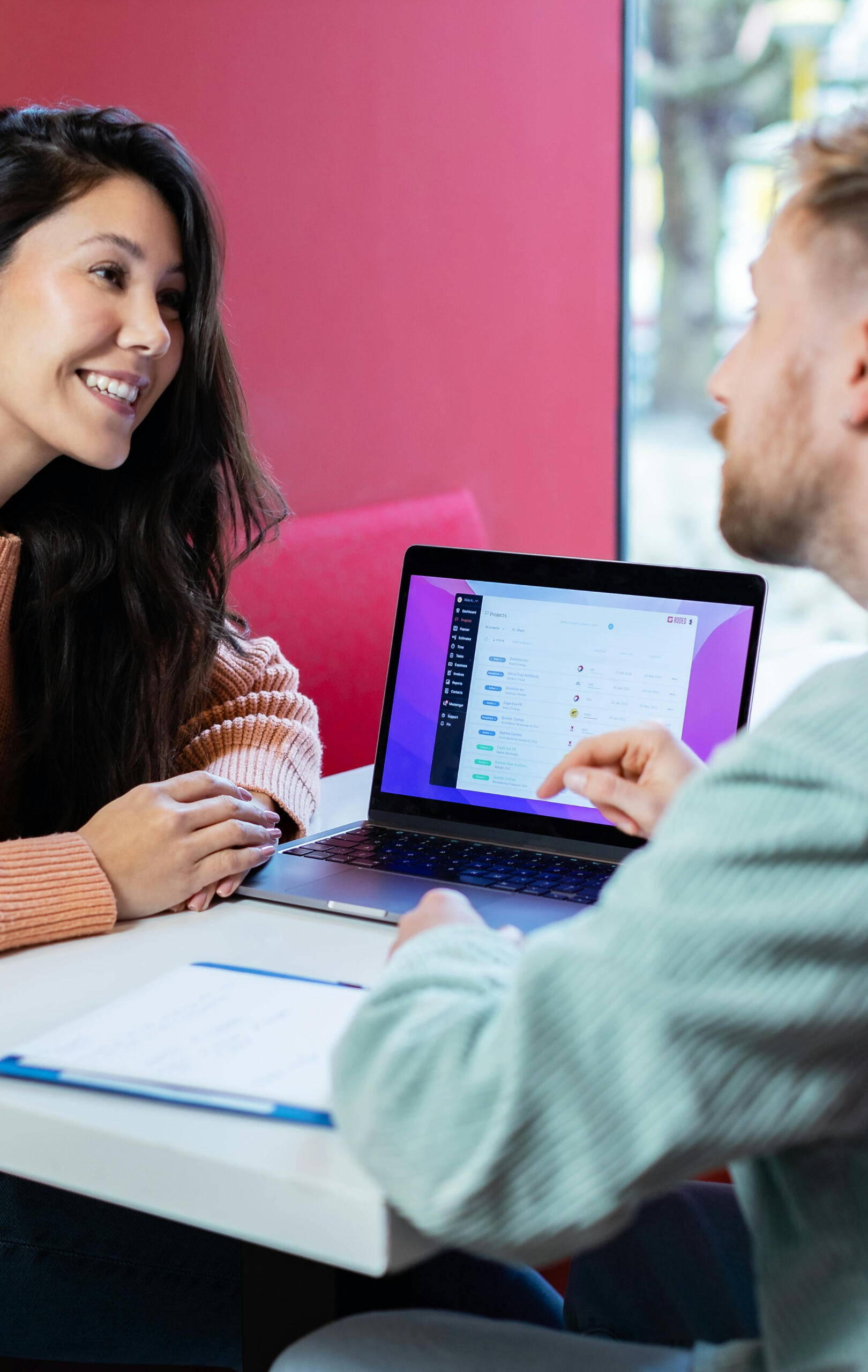 Entrepreneur talking to first customer An entrepreneur talking to first customer in front of a laptop.